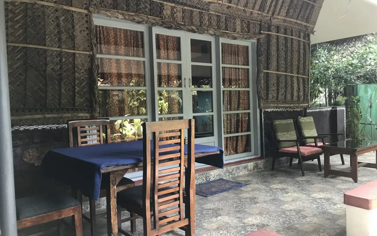 Coconut Leaf Villa veranda at Marari Dreamz; this named cottage uses a shared pool, unlike the separate private-pool villa offers.