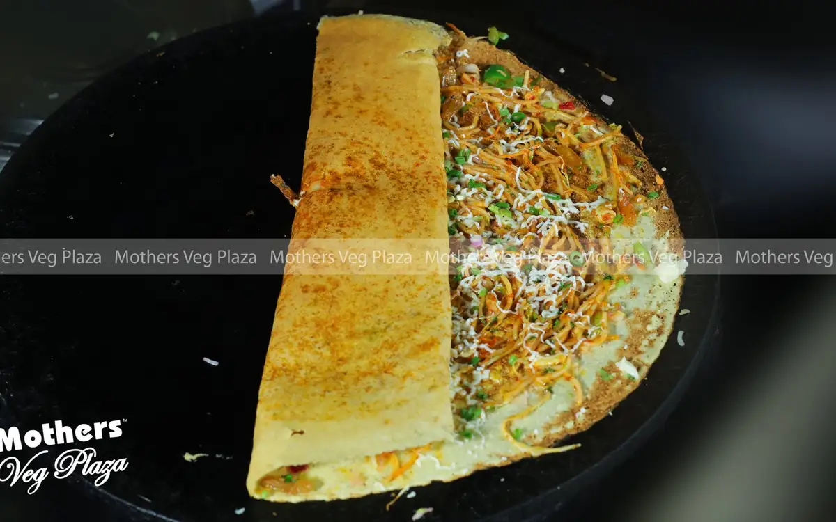 Watermarked dosa photograph published by Mothers Veg Plaza; confirm the dish and serving availability directly.