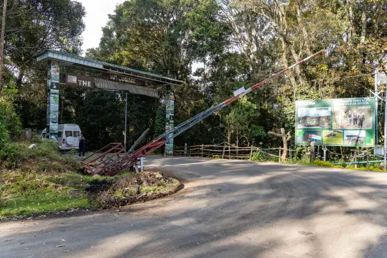 The raised barrier at Pampadum Shola, beside the Vattavada welcome arch and forest-programme board.