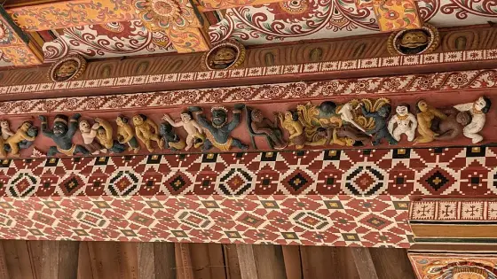 Carved and painted figures beneath the roof.