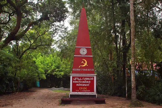 One of several CPI(M) martyrs’ obelisks at Punnapra — not the walled Rakthasakshi Mandapam enclosure itself. The raised date below the hammer and sickle reads 1122, day 7, and 1946 OCT 23.