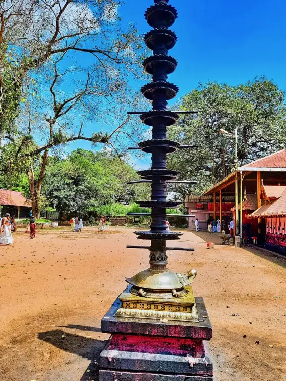 A tall lamp in the Kodungallur temple courtyard.