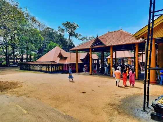 Visitors beside the tiled entrance buildings at Kodungallur Bhagavathy Temple.
