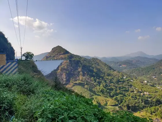 The Idukki arch dam between steep hills, seen across the valley.