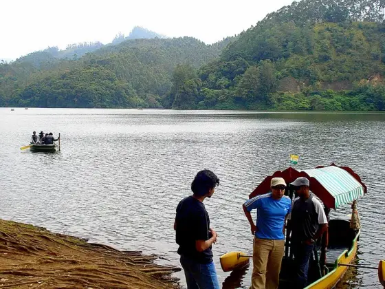 Visitors beside a covered boat at Kundala Lake.