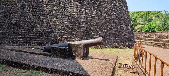 A cannon beside the laterite wall at St Angelo Fort.