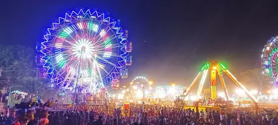 Illuminated fairground rides during the Valliyoorkavu festival; a past festival photograph.