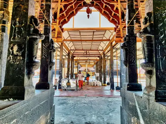 Carved pillars and timber beams along a covered passage.