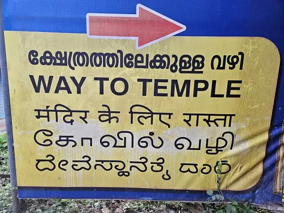 A direction sign pointing towards the temple.