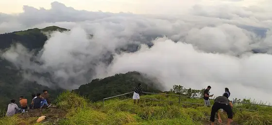 Walkers on the summit ridge in low cloud.