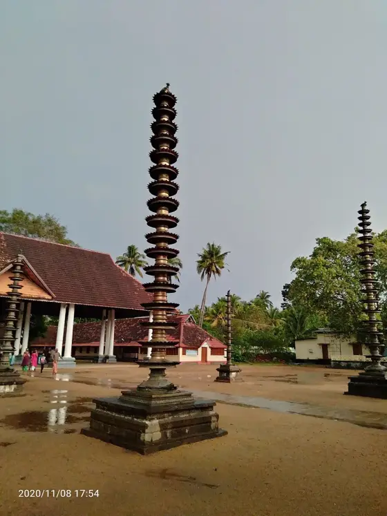 A tall lamp pillar in the Vaikom temple courtyard.