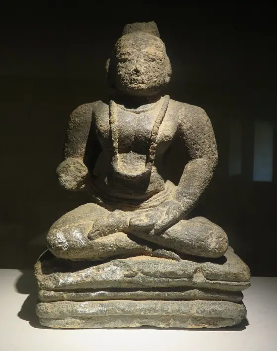 A seated stone figure displayed in Wayanad Heritage Museum.