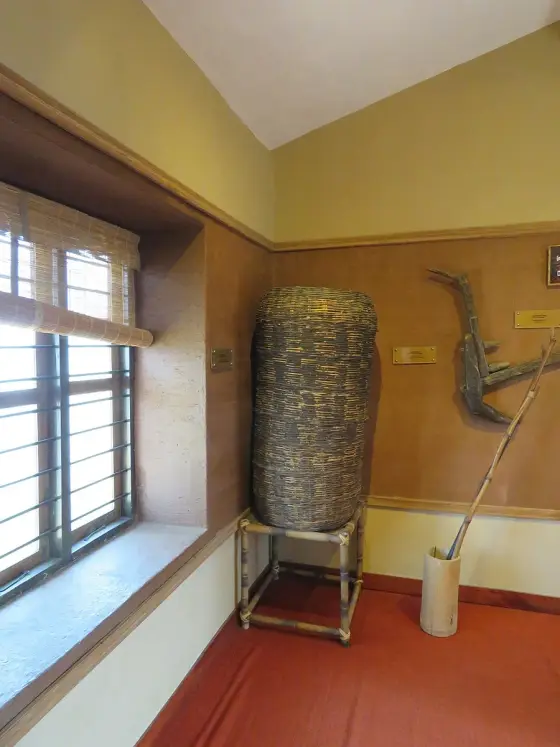 A tall carved stone displayed beside a museum window.