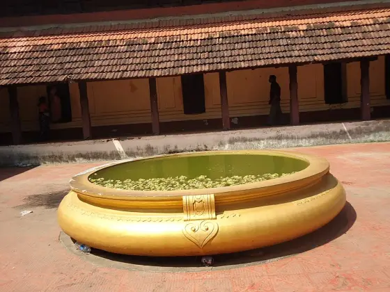 A circular pond in the courtyard of the tiled-roof building.