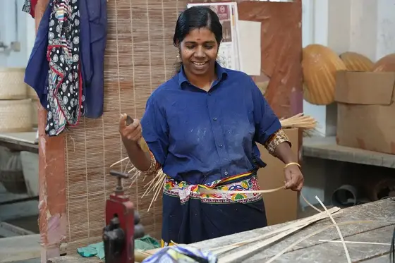 An artisan working with bamboo strips at Uravu.