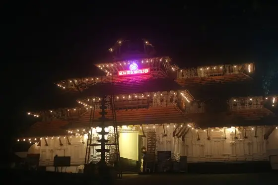 The temple entrance illuminated after dark.