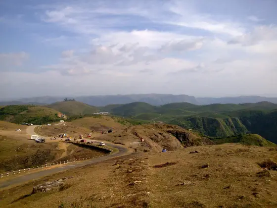 A road bend and small stalls at Parunthumpara in an archival view.