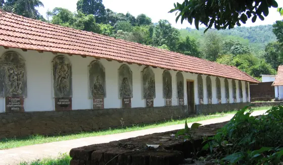 Relief panels run along the temple’s white wall beneath tiled eaves.
