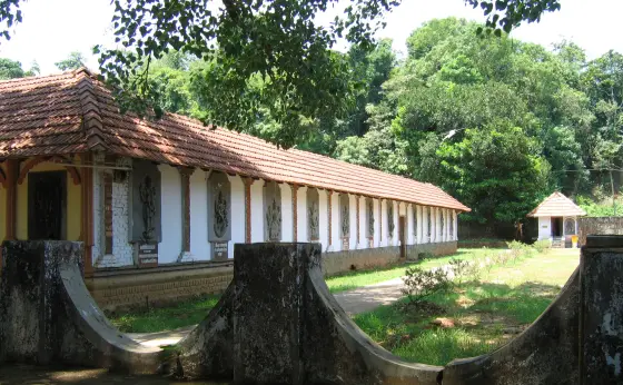 A small shrine stands beside the relief-covered outer wall at Thrissilery.