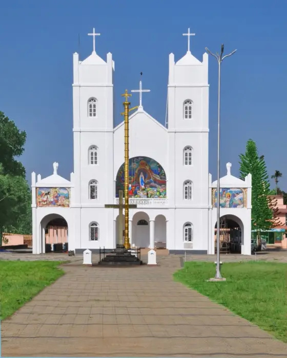The white church front, stone cross and garden at Pallikkunnu.