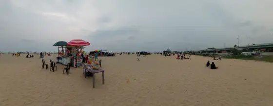 Vendors and umbrellas line the beach, with the elevated bypass on the right.