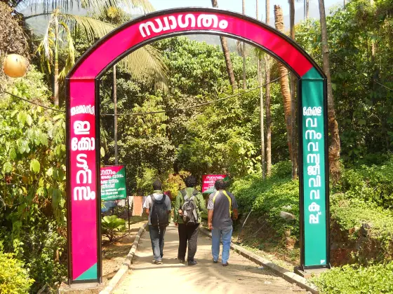 Visitors pass beneath the Thusharagiri entrance arch.
