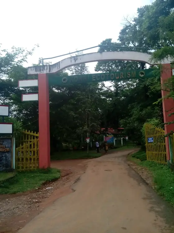 Yellow gates open beneath the Konni elephant-camp entrance arch.