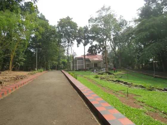 A planted path winds through the Teak Museum campus.