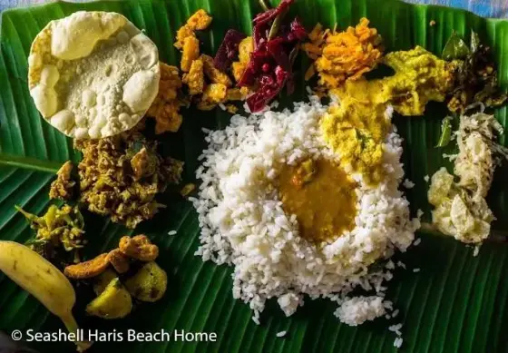 Rice, papad and accompaniments are served on a banana leaf at Seashell Haris Beach Home, a private Adikadalayi property.