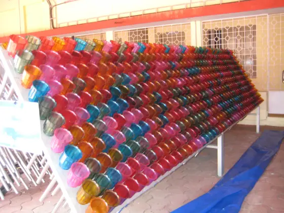 Rows of coloured votive-light cups at the neighbouring Alphonsa shrine.