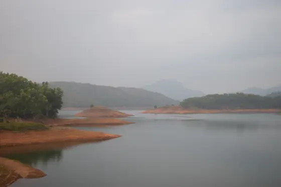 Low-water landforms and wooded slopes within the Kulamavu reservoir landscape.