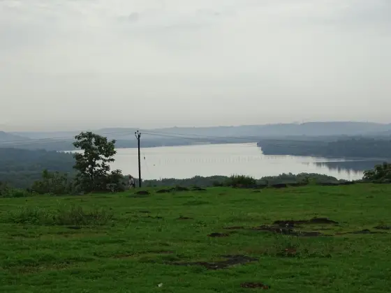 The Pazhayangadi river landscape below Madayipara, viewed across the grassy plateau edge.