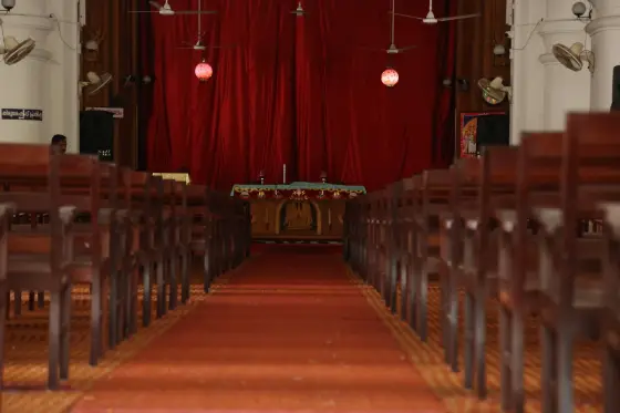 Seating in the parish nave faces the sanctuary; this institutional photograph shows an earlier red-curtain arrangement.