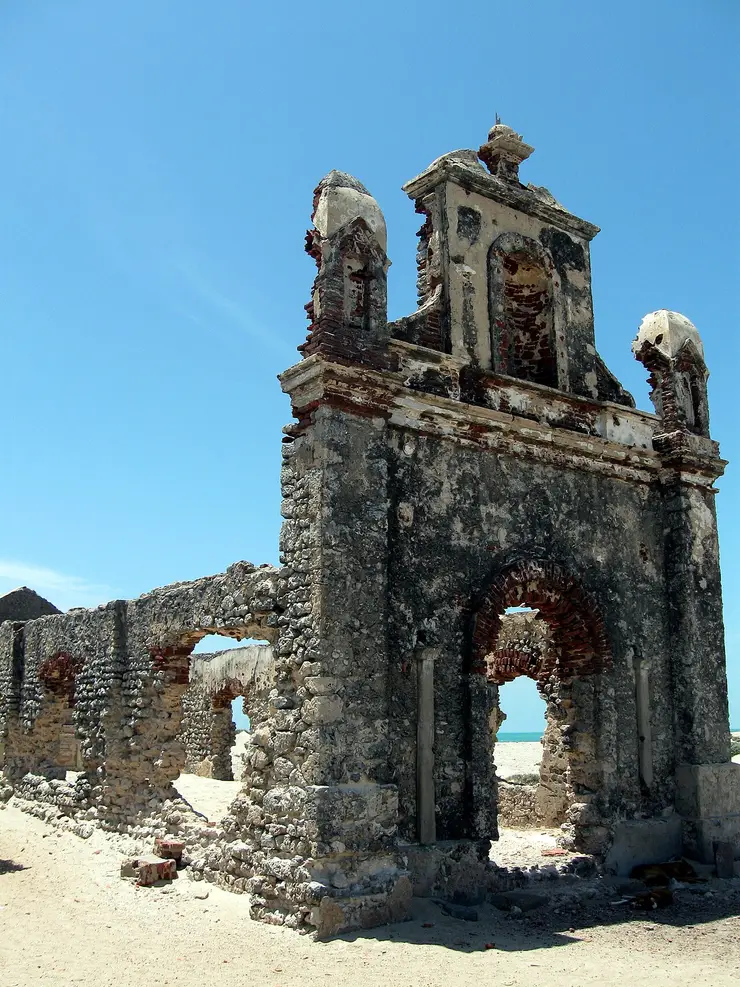 The roofless brick ruins of a church standing amid scrub at Dhanushkodi