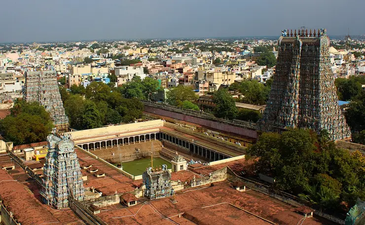 Aerial view of the walled Meenakshi Amman Temple complex in Madurai, its tall painted gopurams rising above the old city