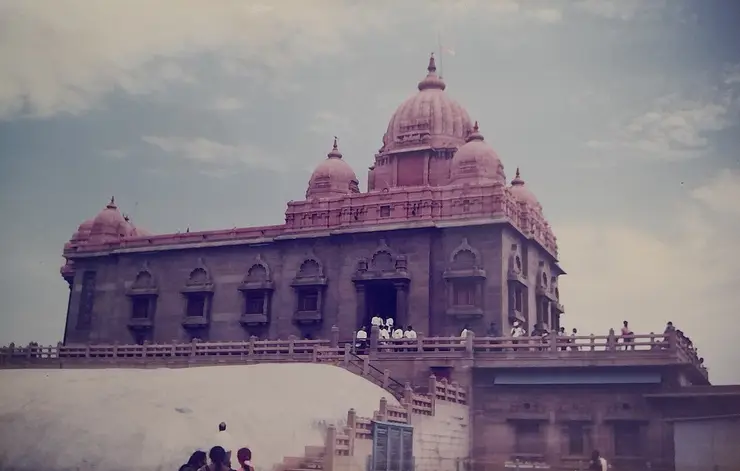 The domed stone Vivekananda Mandapam of the Vivekananda Rock Memorial, flying a saffron flag, on its islet off Kanyakumari.