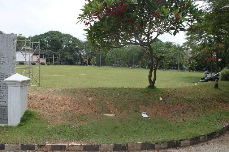 The open maidan of the Durbar Hall Ground in Ernakulam, with a marked pitch and an inscribed stone at the edge