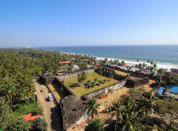 Aerial view of Anchuthengu Fort, a walled rectangle with corner bastions on a narrow strip between the Arabian Sea and a backwater