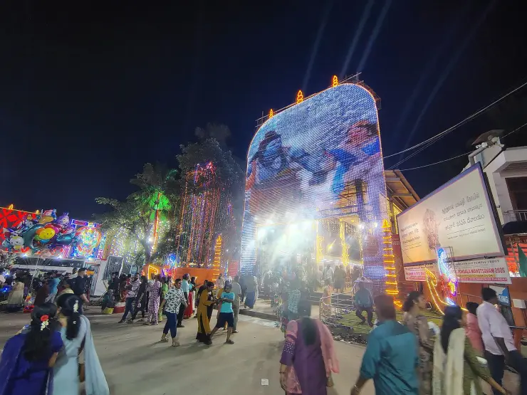 The Attukal Bhagavathy Temple entrance illuminated at night during the Pongala Mahotsavam, with the festival dates displayed on a board outside