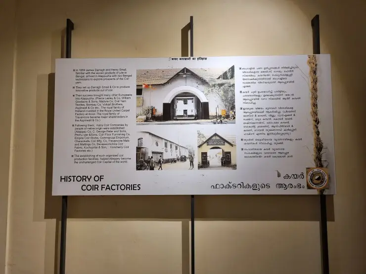A bilingual museum wall panel titled History of Coir Factories, with period photographs of factory gates and blocks of English and Malayalam text