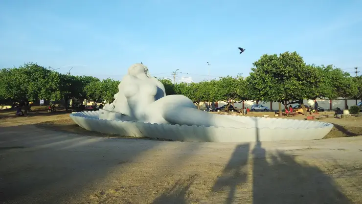 The Sagarakanyaka, a huge white reclining mermaid sculpture on a shell-shaped base at Shanghumukham beach
