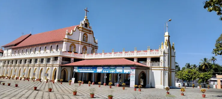The west front of St George Forane Church, Edathua — a red-tiled arcaded hall with a curvilinear gable and a Gothic porch block