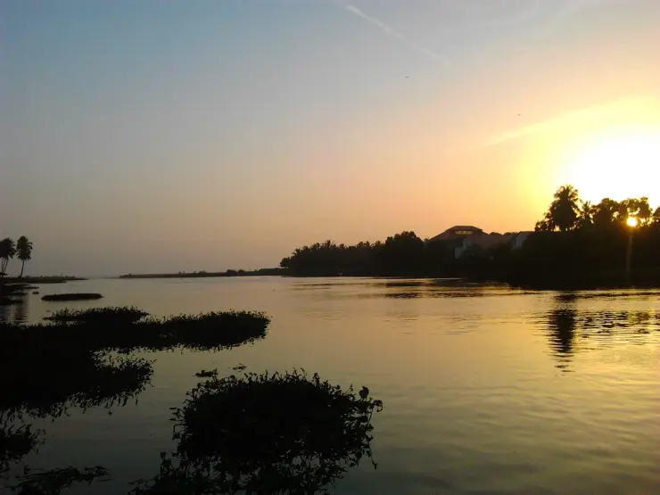 Sunset over Veli lagoon with weed islands in the foreground and the tourist village buildings silhouetted on the far bank