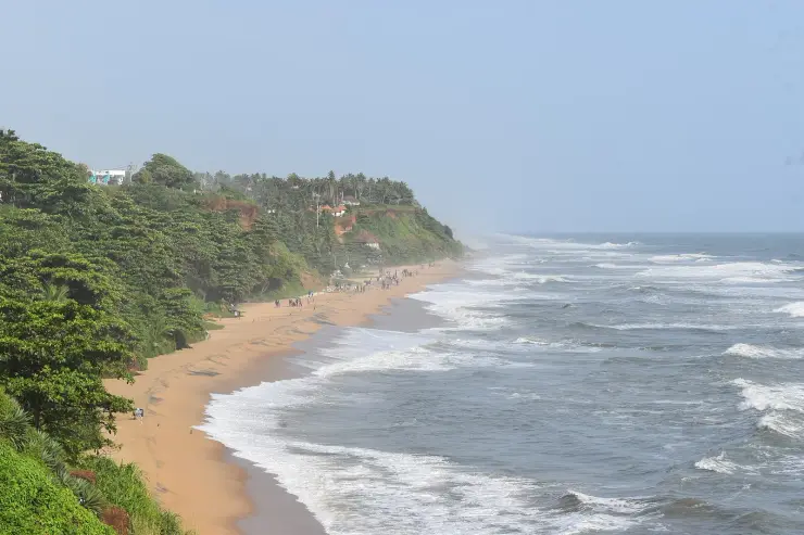The Varkala cliff line running north above the beach, vegetation rooted in the laterite cap