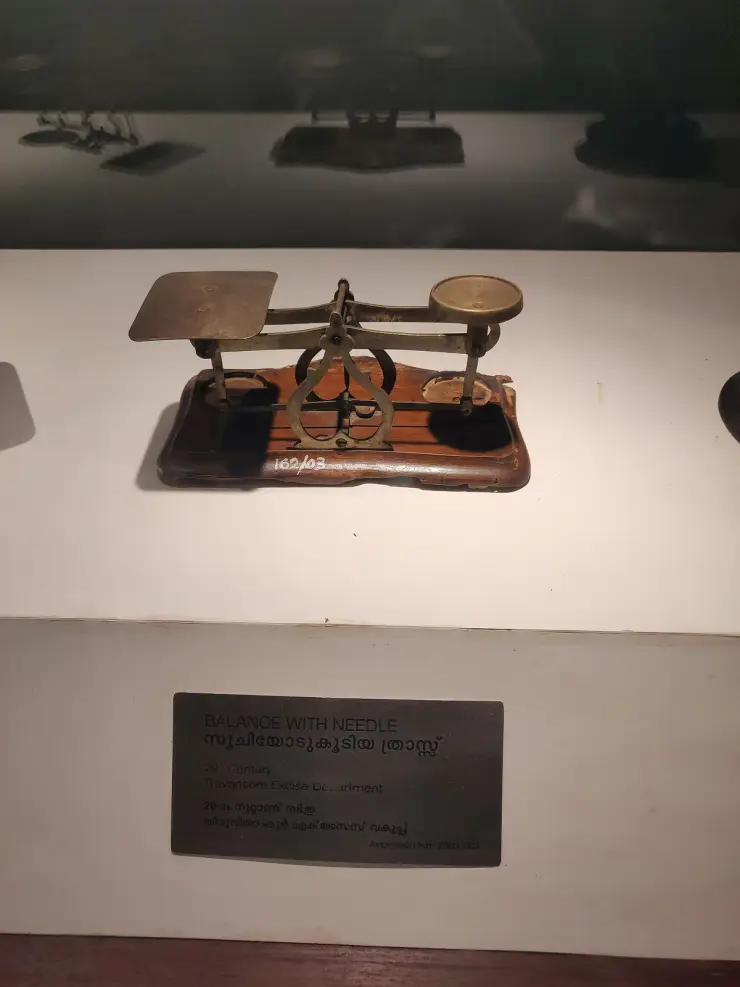 A brass balance from the Travancore Excise Department displayed at the Pazhassi Raja Archaeological Museum, Kozhikode