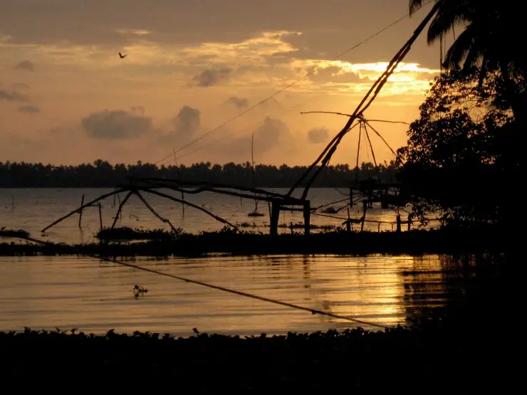 A Chinese fishing net silhouetted at sunset in the Kochi backwaters