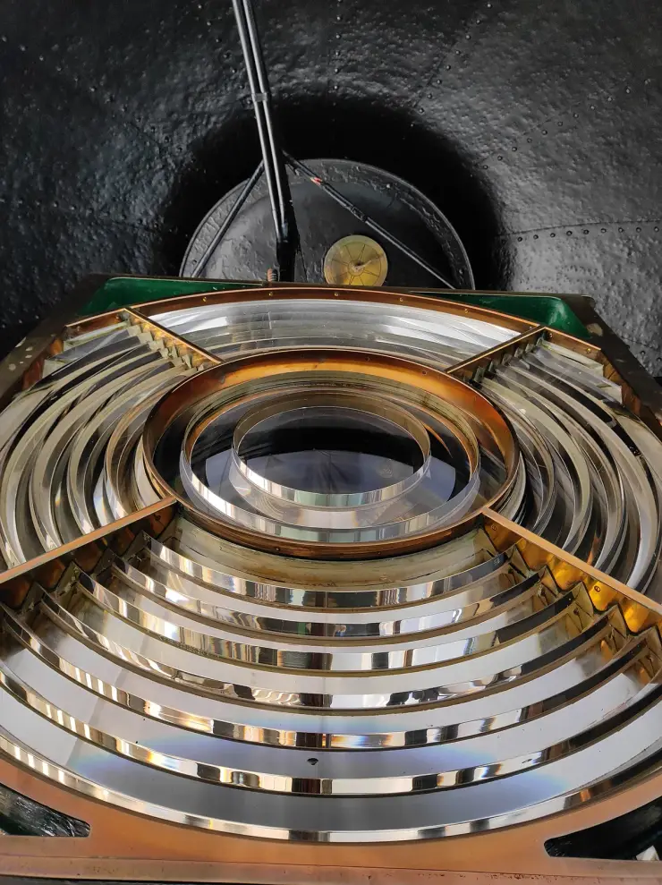 The revolving glass optic inside the Thangassery lighthouse lantern, a tall assembly of curved and stepped prisms surrounding the lamp.