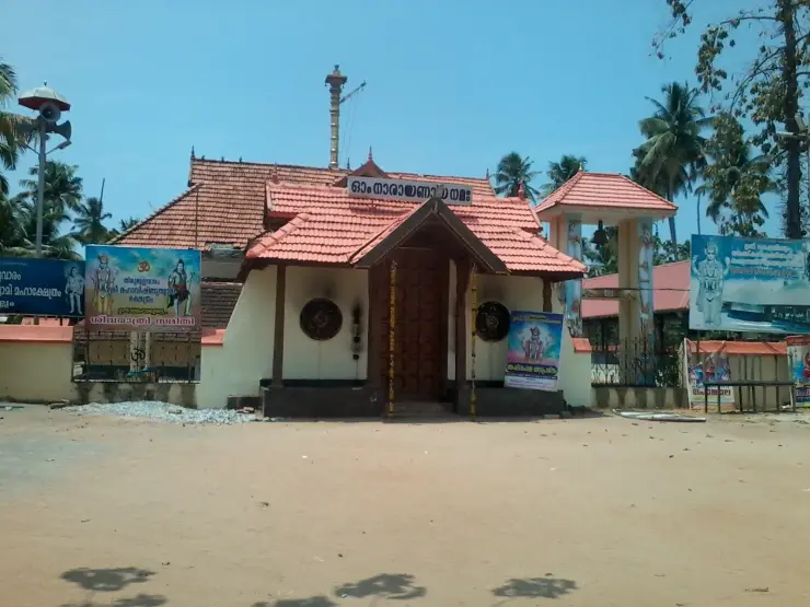The entrance of the Thirumullavaram Sree Maha Vishnu Swami temple, with a painted board above the gateway and a banner on the compound wall.