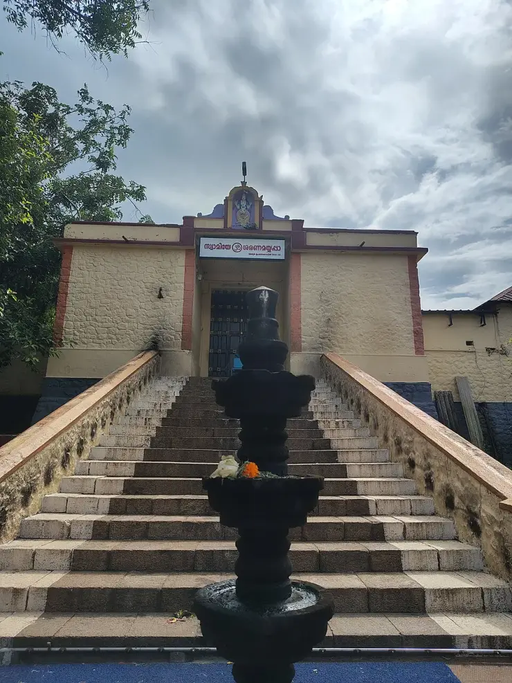 A broad flight of stone steps rising to the dark closed timber door of the main shrine, with a tall black stone lamp-post standing in front of it
