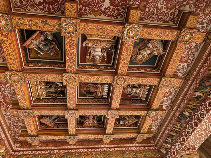The carved and painted wooden ceiling of the Shiva shrine at Lokanarkavu Temple near Vadakara, with deity figures set in coffered panels